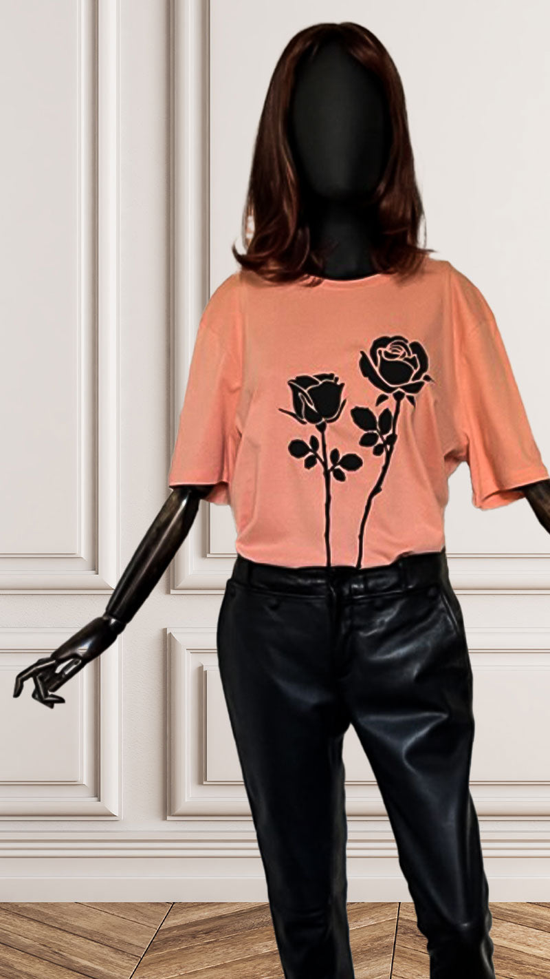 "Feeling Rosie" is an organic cotton soft orange T-shirt printed with two large puffy black roses on the front of the shirt with stems running till the end.