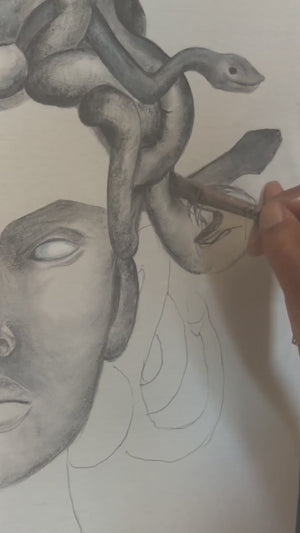 Hand-painting Medusa on a white organic shirt
