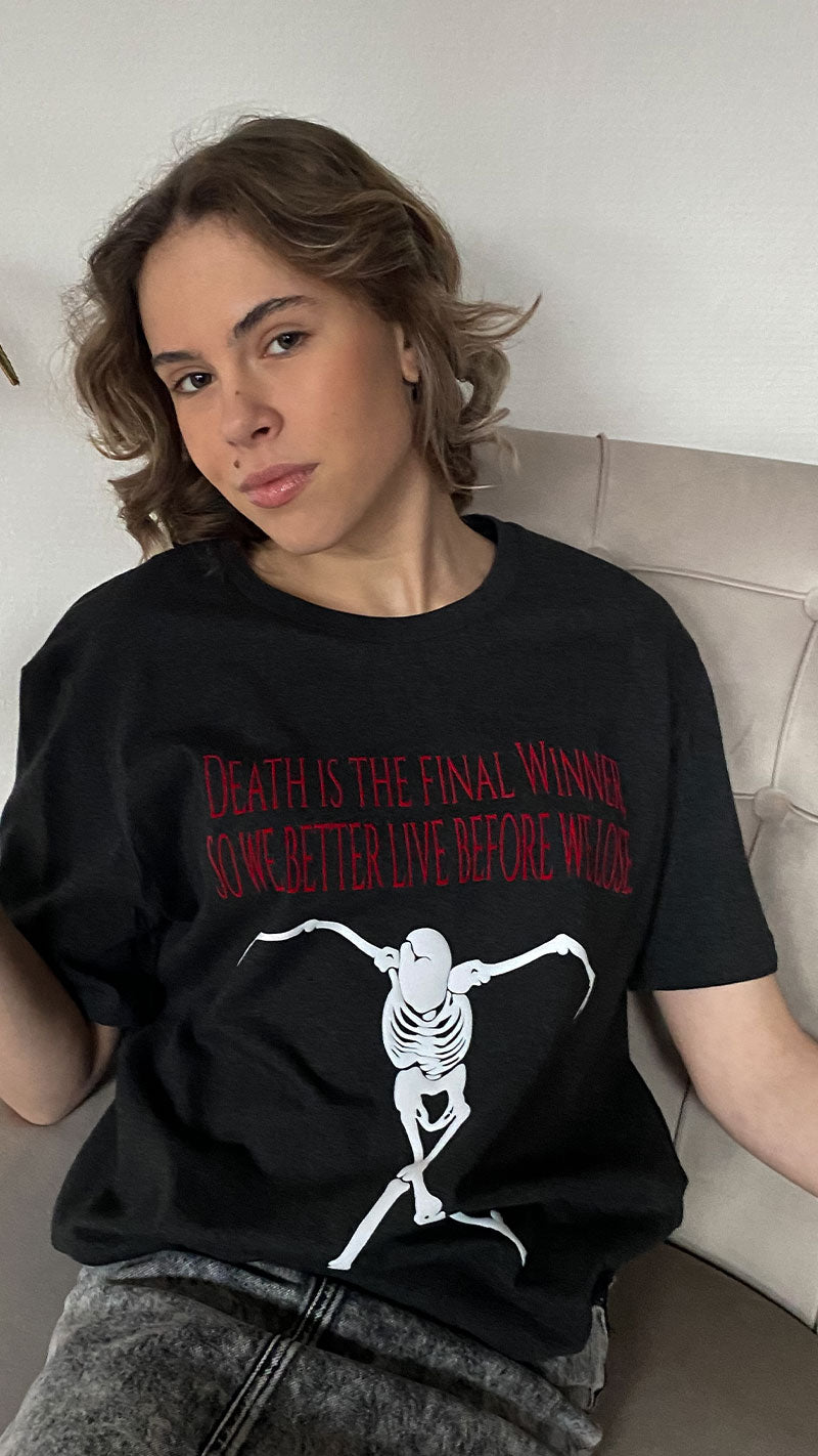 T-shirt The Winner with text saying: "Death is the Final Winner, so we better Live before we Lose" by Atelier Astrid & Antoinette